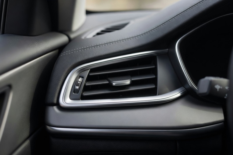 A car dashboard air vent seen close up in daylight