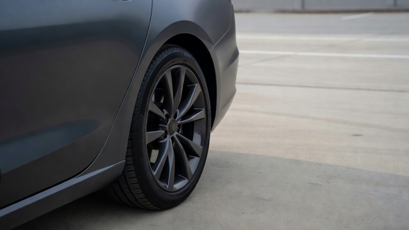 A rear wheel arch on a modern car, showing a wider rear tyre against the bodywork